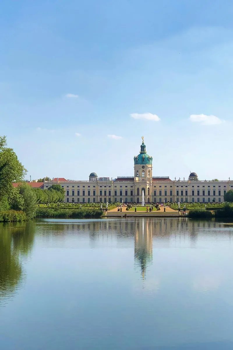 The Baroque facade and green dome of Charlottenburg Palace in Berlin under a clear sky